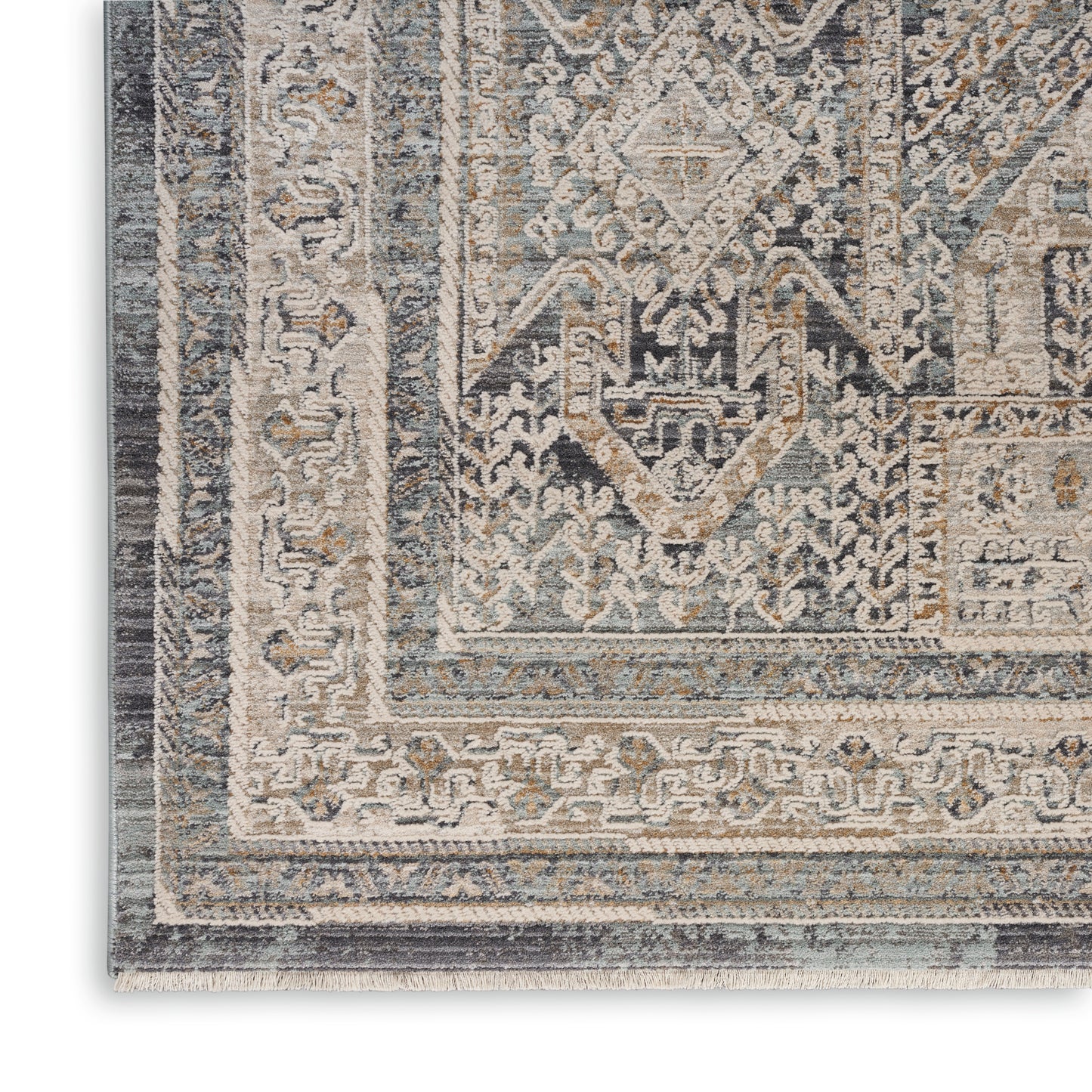 Close-up of a distressed gray and beige oriental rug with a geometric medallion and ornate borders.