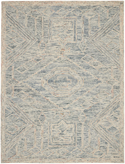 Blue-gray area rug with cream geometric medallions and peach accents in a distressed, vintage-inspired tribal pattern.