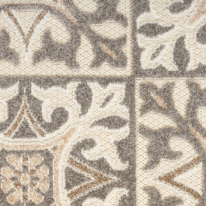 Beige and gray ornate tile-pattern rug with floral scroll motifs in a textured loop pile.