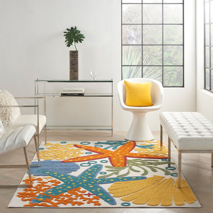 Bright modern living room with glass console table, tall plant vase, white chair with yellow cushion, and a colorful starfish rug.