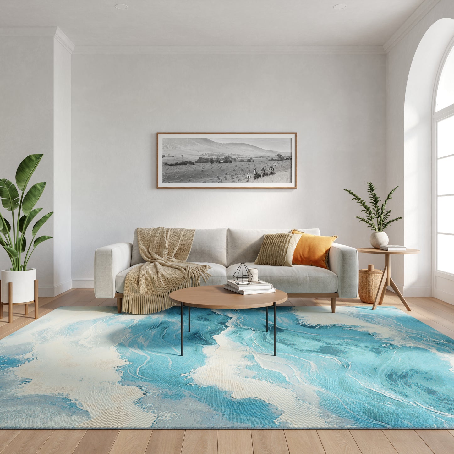 Modern living room with light gray sofa, beige throw, orange cushion, round wood coffee table, blue abstract rug, and green plants.