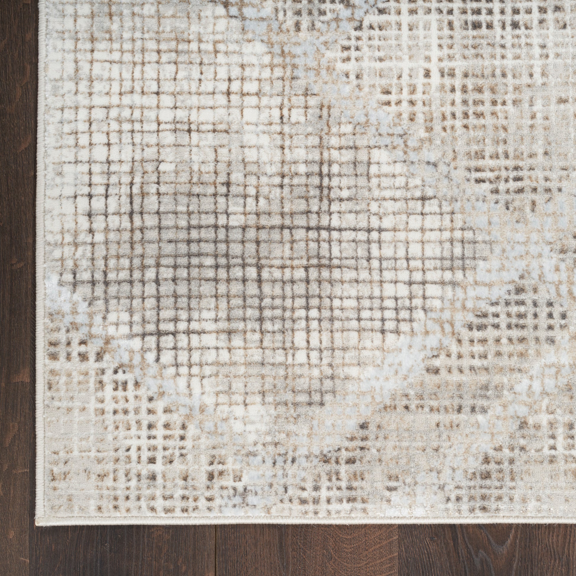 Cream and beige distressed geometric runner rug with a grid and diamond pattern on dark wood floor
