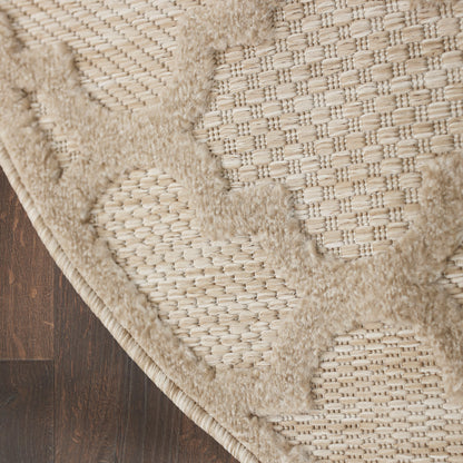 Beige round area rug with woven base and plush geometric circle patterns on dark wood floor.