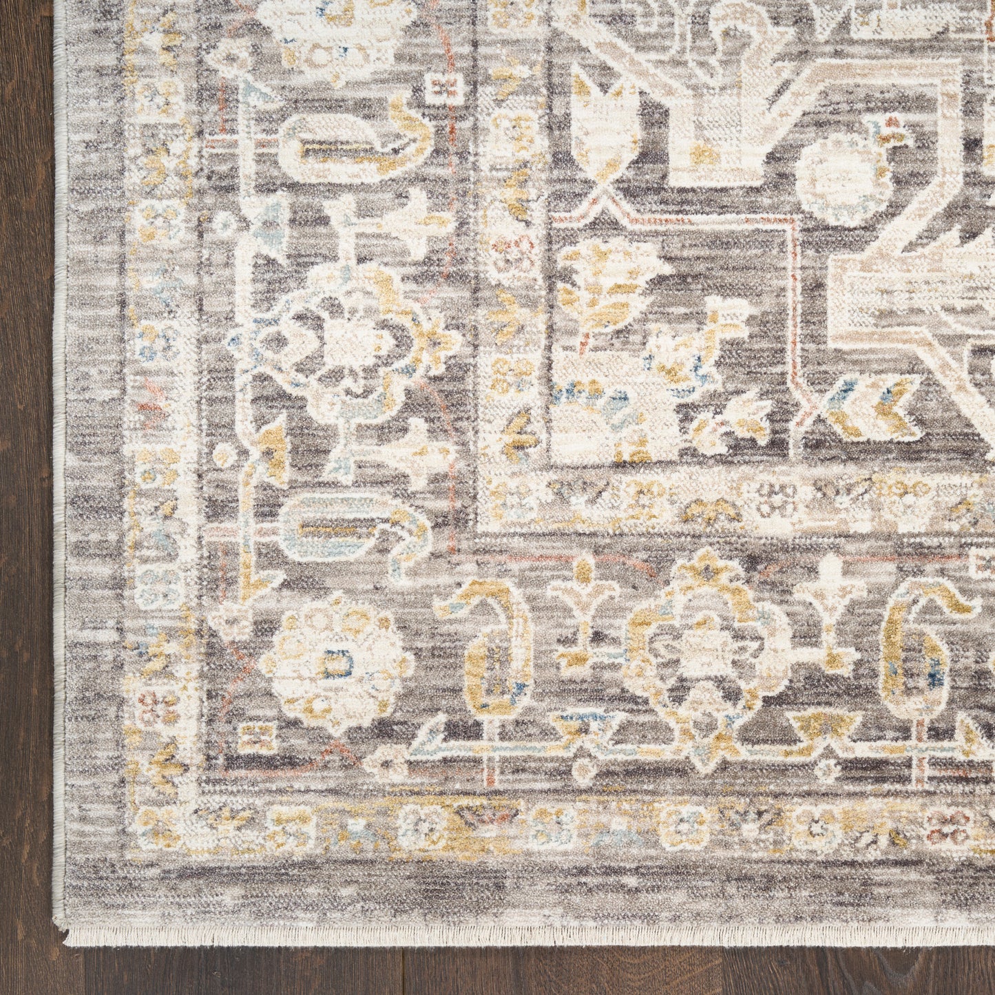 Traditional oriental-style runner rug in gray, ivory and pale yellow on a dark wood floor.