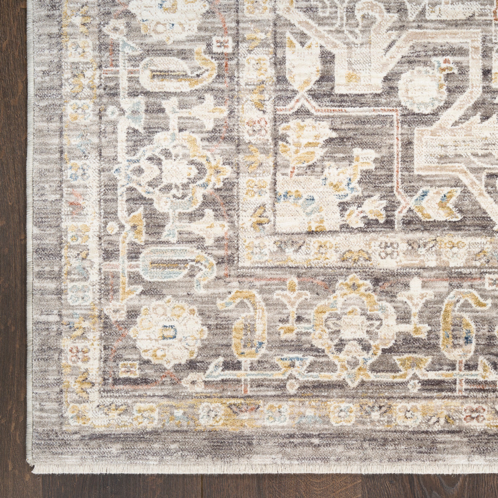 Traditional oriental-style runner rug in gray, ivory and pale yellow on a dark wood floor.