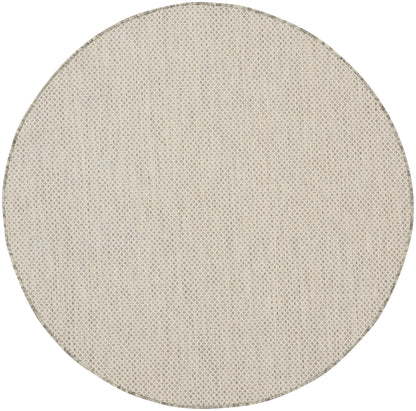 Round beige woven rug with natural fiber texture; neutral floor decor for living spaces.