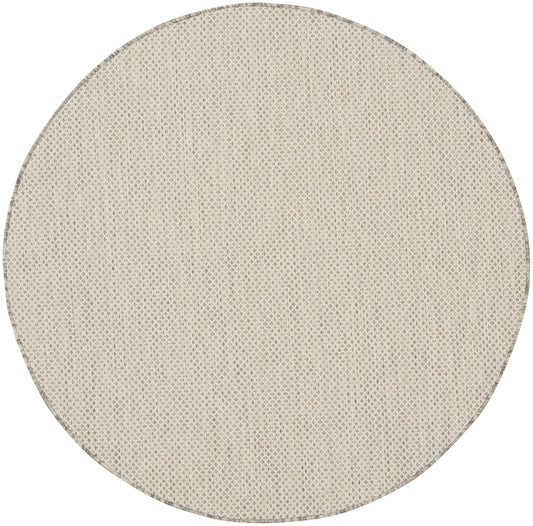 Round beige woven rug with natural fiber texture; neutral floor decor for living spaces.