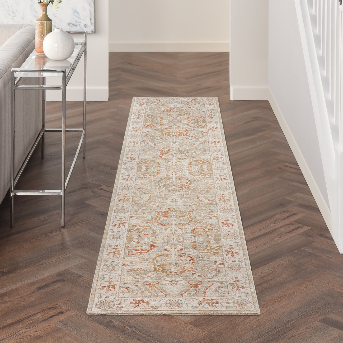 Cream oriental hallway runner rug with peach & sage floral motifs, long rectangular, in a modern entryway with a glass-top console.