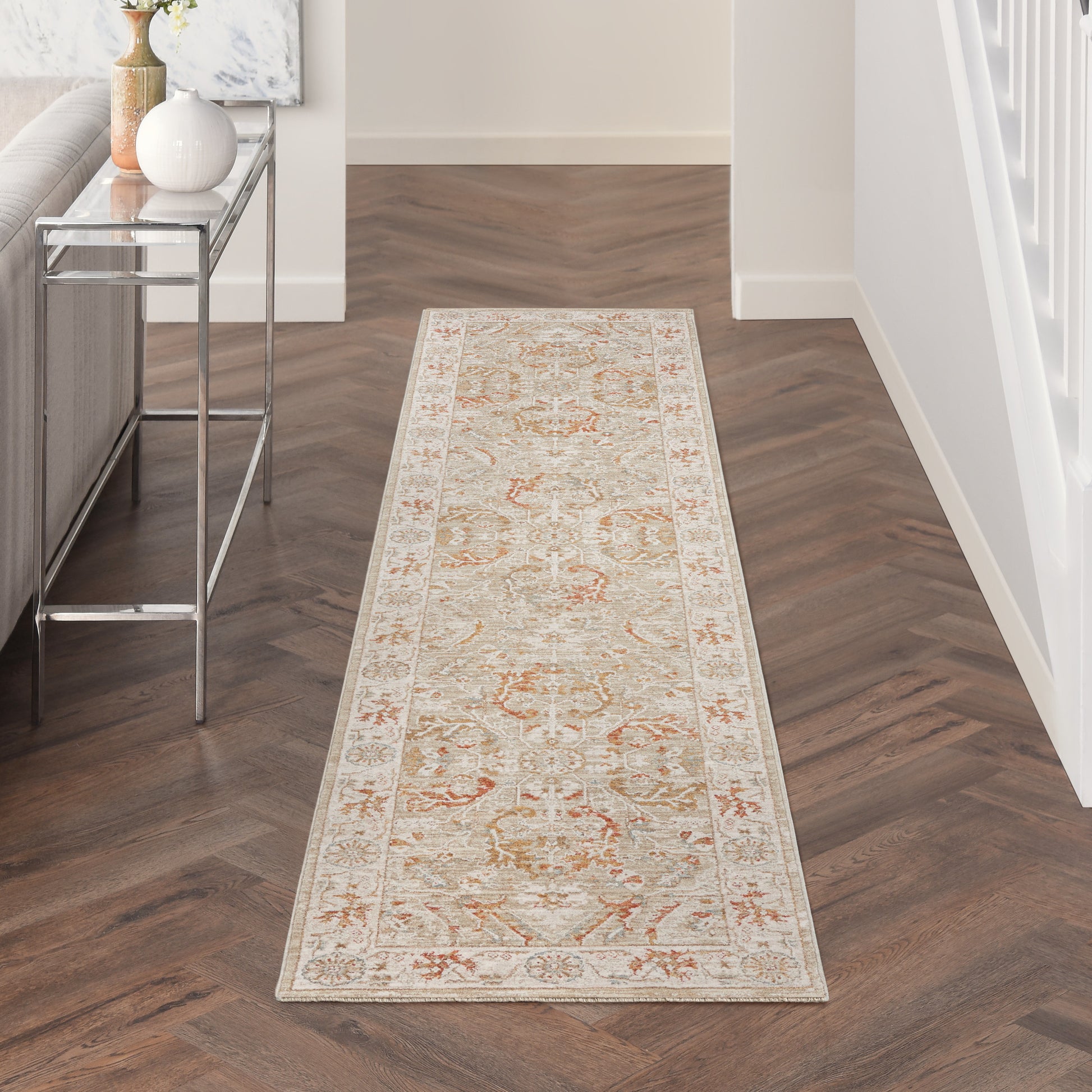 Cream oriental hallway runner rug with peach & sage floral motifs, long rectangular, in a modern entryway with a glass-top console.