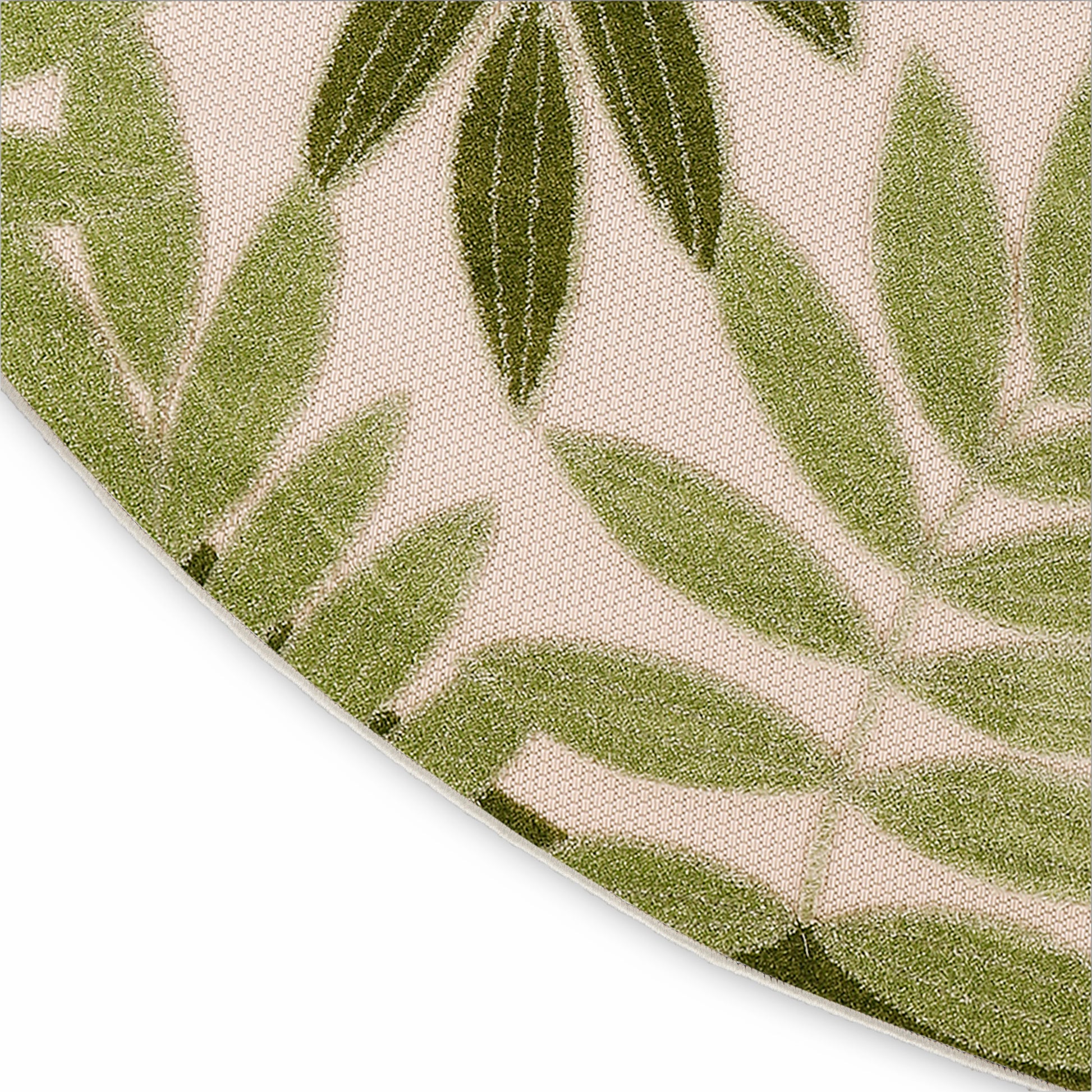 Round beige rug with green botanical leaf pattern; close-up showing curved edge.