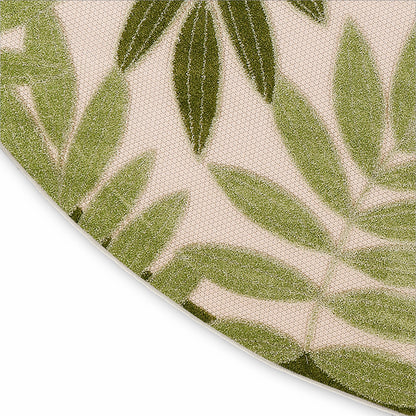 Round beige rug with green botanical leaf pattern; close-up showing curved edge.
