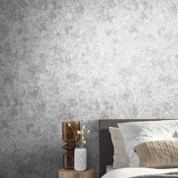 Textured grey wallcovering with a silver-grey finish on a wall; close-up view of the wallpaper pattern.