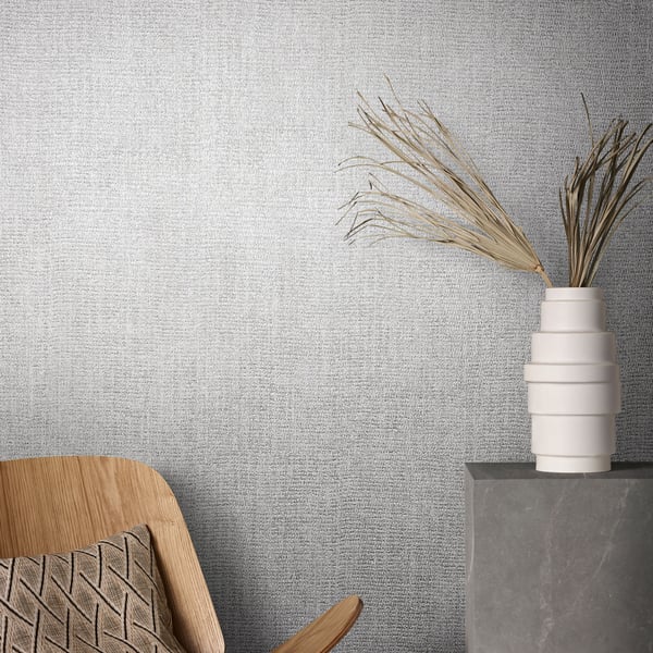 Silver-grey wallcovering with a subtle wave texture, displayed on a wall in a room setting.