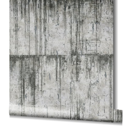 Wallpaper roll with concrete texture, silver-grey tones and black vertical drips on a distressed industrial backdrop.