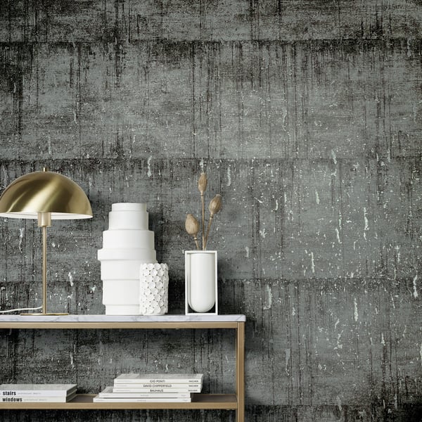 White ceramic vases, a stack of white cake stands, and a gold dome lamp on a console shelf, against a gray wall.