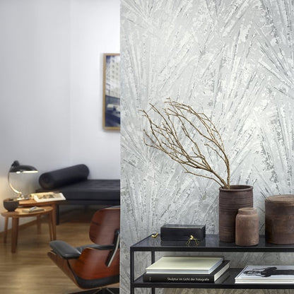 Modern living room with textured gray palm-leaf wallpaper; black metal console holds brown ceramic vases and dried branch.
