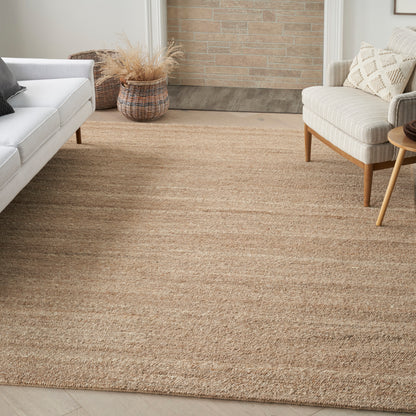 Large natural jute rug in warm beige tones under living room seating with cream sofa, beige chair, and wooden side table; 6' x 8'.