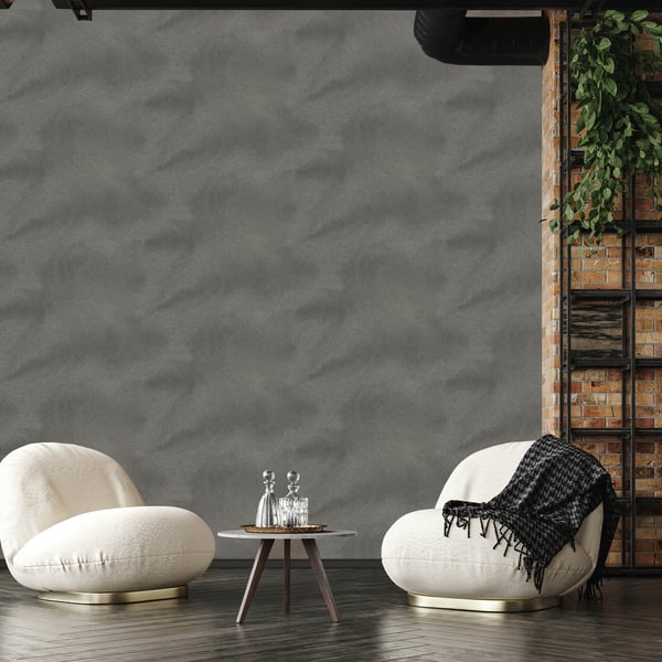 Two cream rounded lounge chairs with a small round table and glass decanters in front of gray textured wall wallpaper.