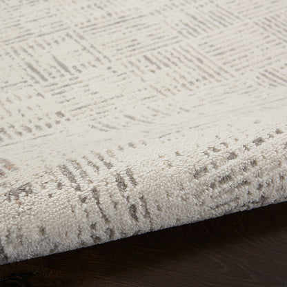 Cream textured rug with subtle geometric pattern and plush pile, laid on a dark wooden floor.