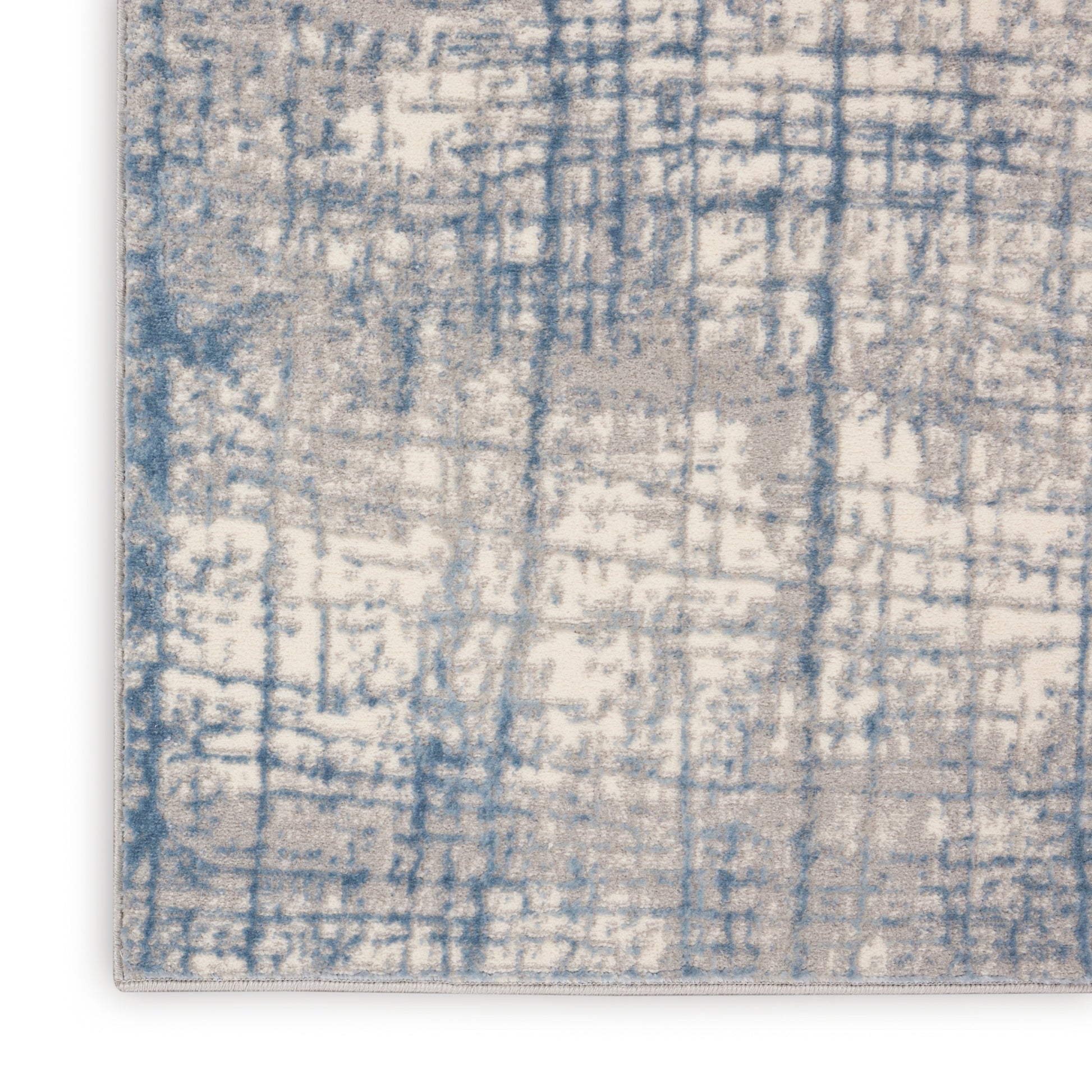 Rectangular runner rug with blue and cream distressed abstract grid pattern and light edge binding.