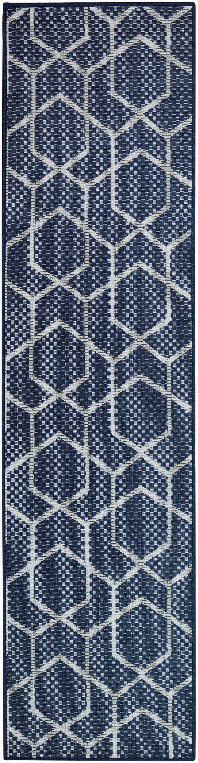 Navy blue runner rug with white geometric hexagon lattice pattern and woven texture.