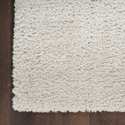 Cream high-pile shag rug on dark wood floor; plush, fluffy texture and rectangular cozy living-room style.