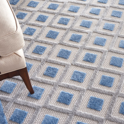 Gray textured rug with blue square accents in a geometric grid.