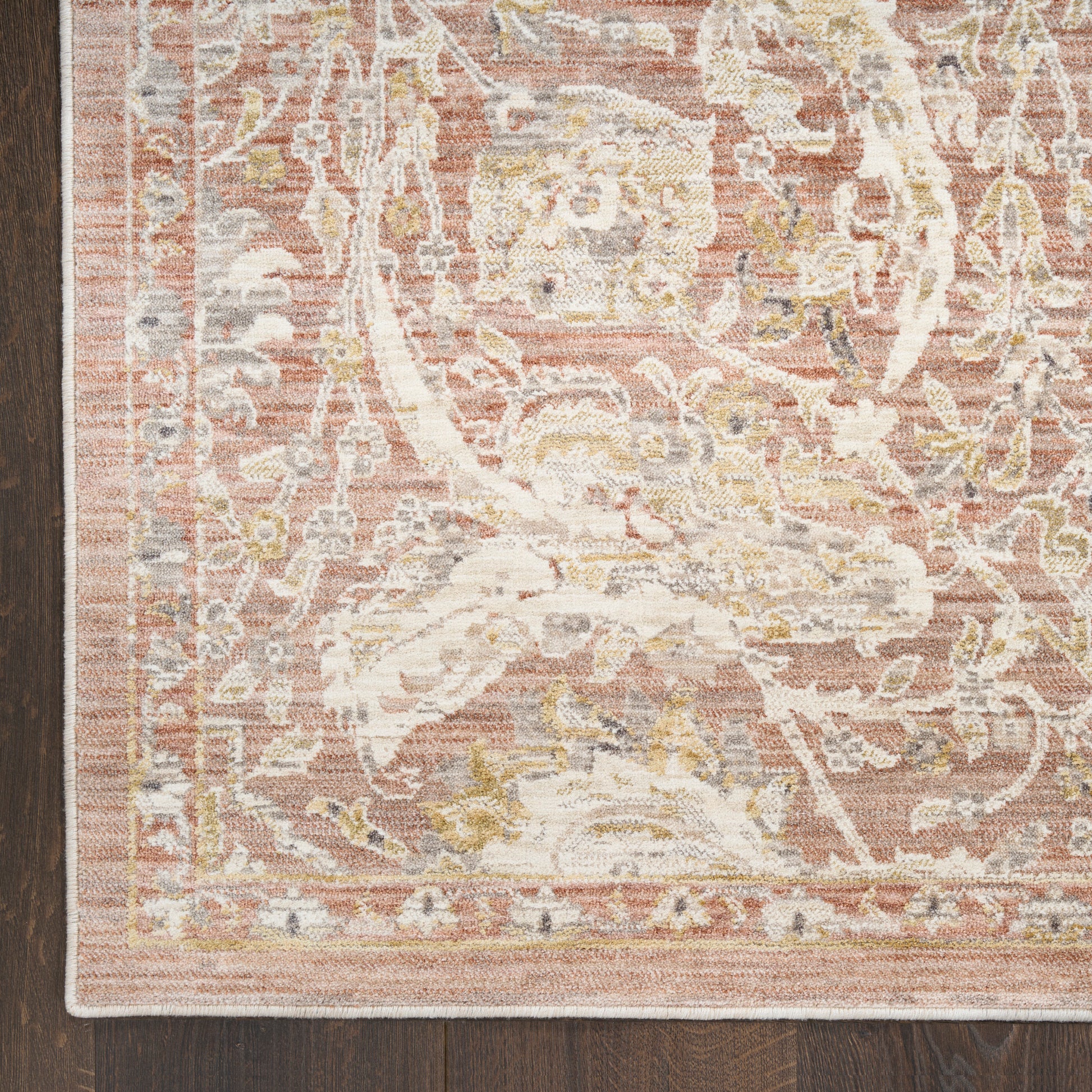 Soft pink rug with ivory floral arabesque pattern, distressed vintage look, rectangular shape, plush textile for living room.