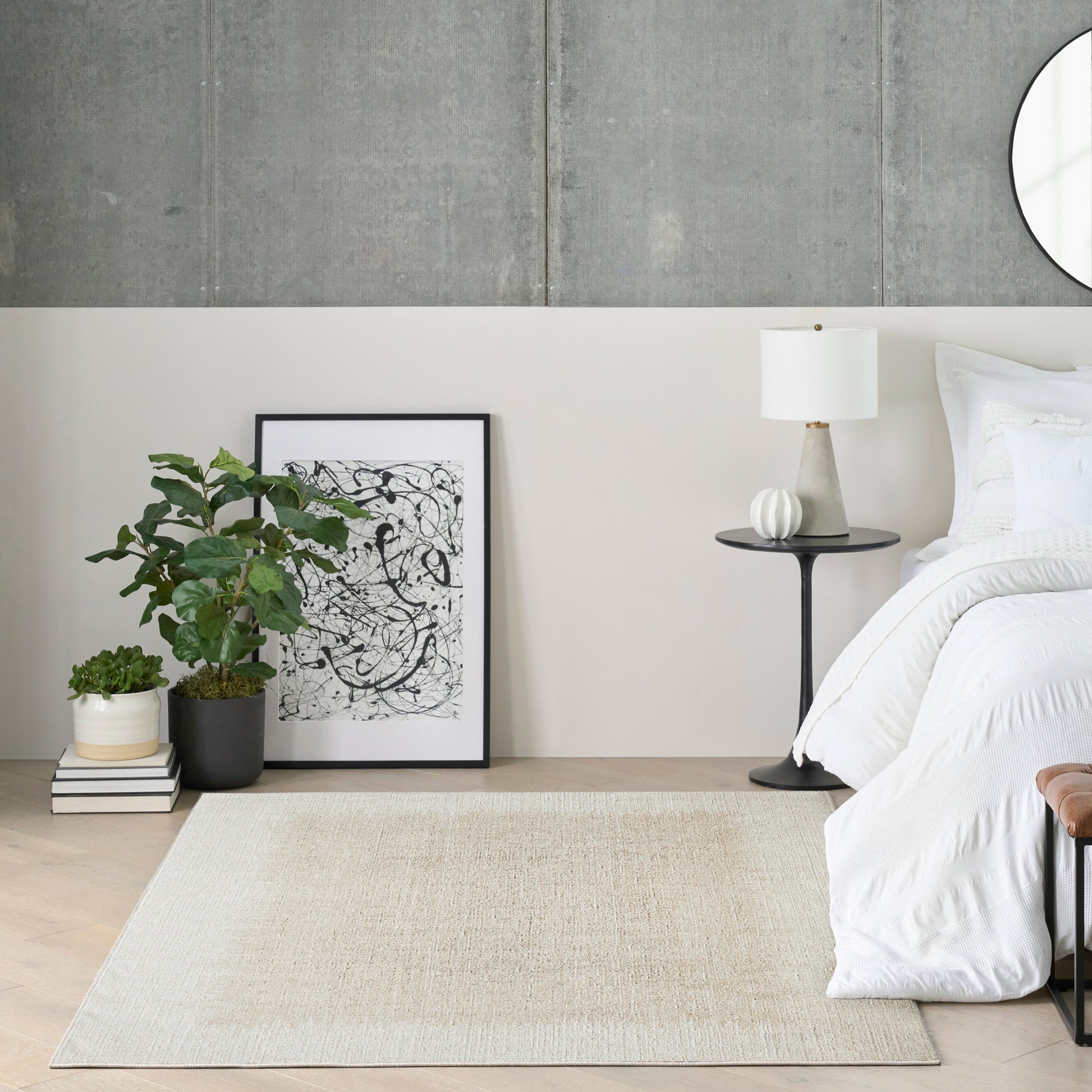 Minimalist bedroom corner: concrete wall, white bedding, black side table with lamp, abstract art, potted plants, beige rug