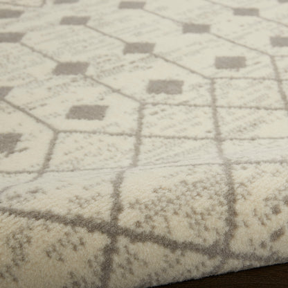 Cream and gray plush area rug with hexagon and diamond geometric pattern on a wood floor.