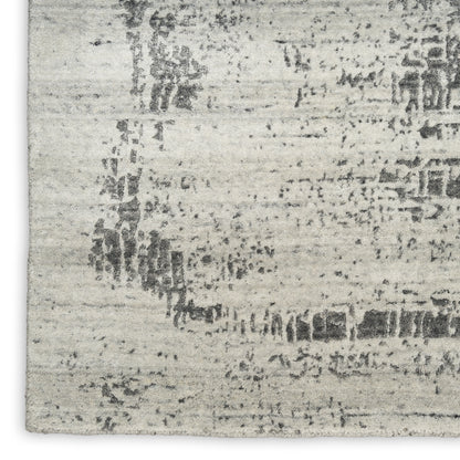 Light gray distressed area rug with an abstract dark pattern; rectangular, soft textured home decor.
