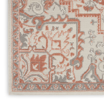 Close-up of ivory oriental rug corner with peach and gray floral motifs and ornate border.