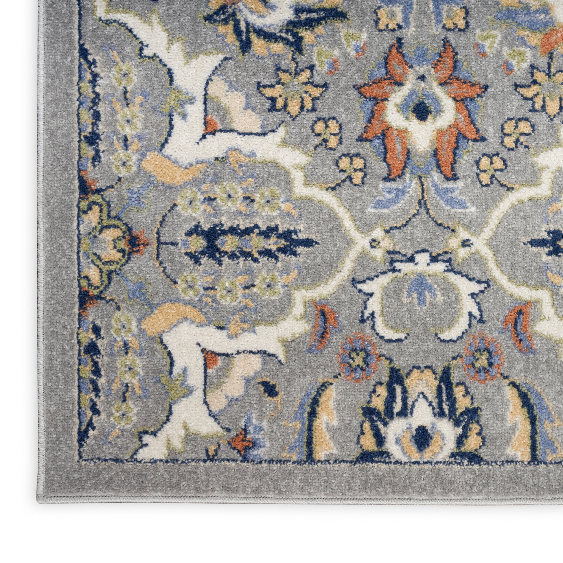Close-up view of a gray oriental rug with blue, ivory, and peach floral motifs and a decorative border.