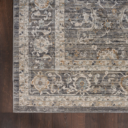 Rectangular traditional oriental rug in gray, ivory, blue and tan with a floral border on dark wood floor.