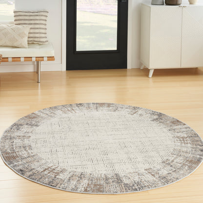 Round gray-beige rug on light wood floor in a modern living room.