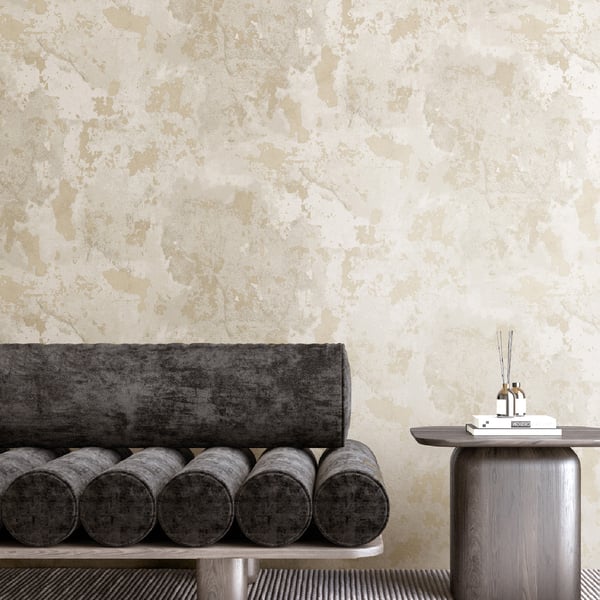 Modern living room: beige textured wall, dark gray cylindrical bolsters on a low bench, rounded gray side table with books.