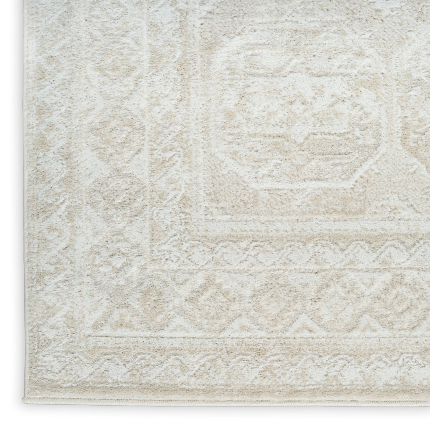 Cream textured area rug with subtle geometric medallion pattern, bound edge and plush pile.