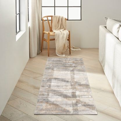 Neutral abstract rug runner in gray-beige tones on light wood floor, with a wooden chair and cream throw.