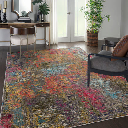 Colorful abstract area rug on dark wood floor in a modern living room with desk, plant, and gray lounge chair.