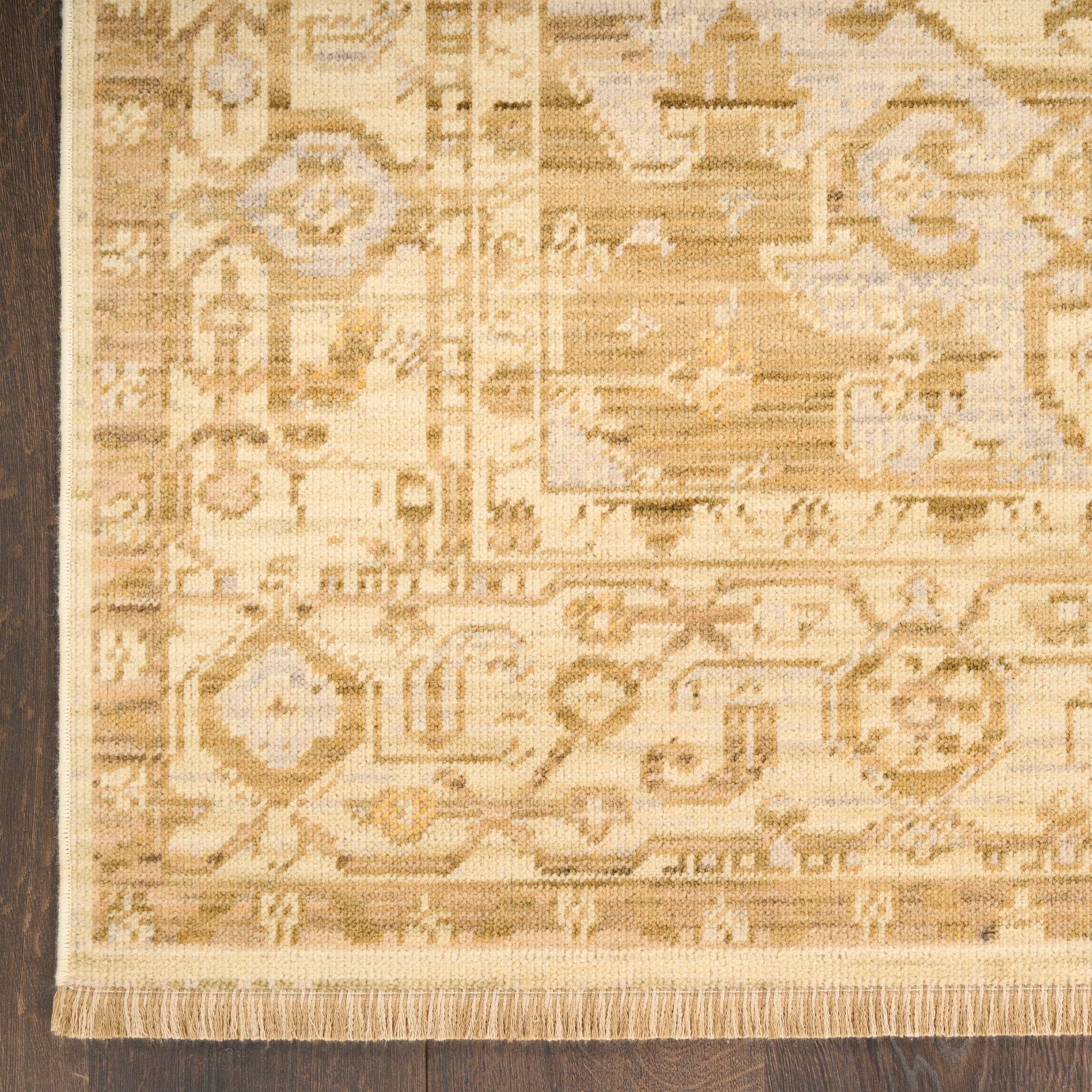 Beige oriental rug with geometric and floral motifs, light tan and cream tones, fringed edges.