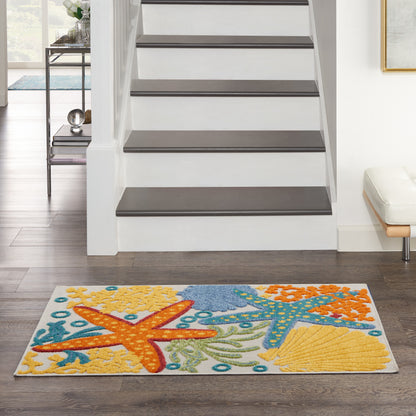 Rectangular coastal area rug with orange starfish, blue sea motifs and yellow shells on white, in a modern living room.