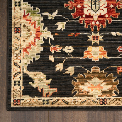 Close-up of oriental rug with black field, red and cream floral motifs, and a beige border on dark wood floor.