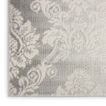 Close-up of damask patterned woven textile in ivory on grey; ornate decor fabric.