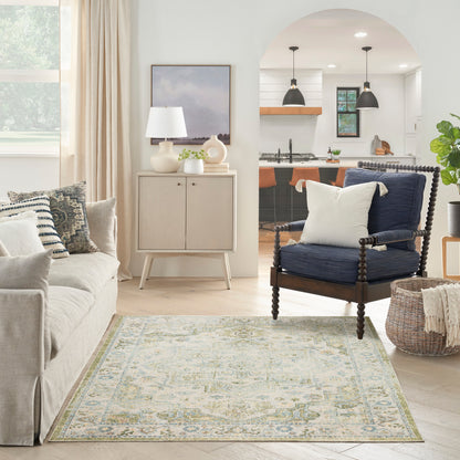 Bright living room with beige sofa, blue spindle chair, pale blue patterned rug, light wood cabinet, white lamp.