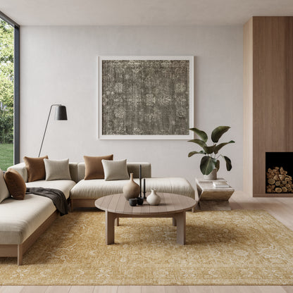Neutral living room with beige sectional, wood coffee table, golden rug, black floor lamp, abstract art, fireplace, plant.