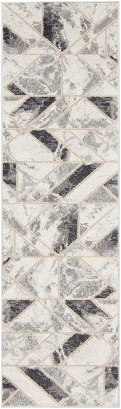Vertical geometric mosaic tile pattern in beige, cream and gray triangles with terrazzo texture.