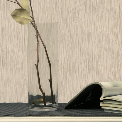 Clear glass vase with water and tall brown branches, pale green leaf, on a dark woven mat beside a curled-open magazine.