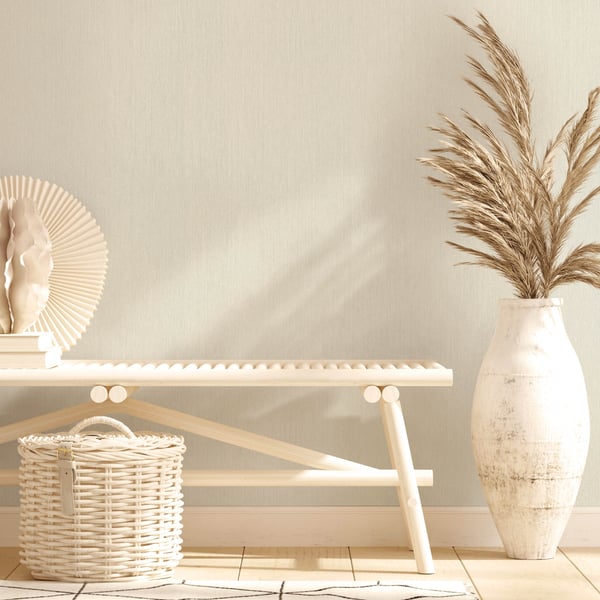 Neutral-toned living space featuring a wooden bench, round wicker basket, decorative plate, and a tall white vase with pampas grass.