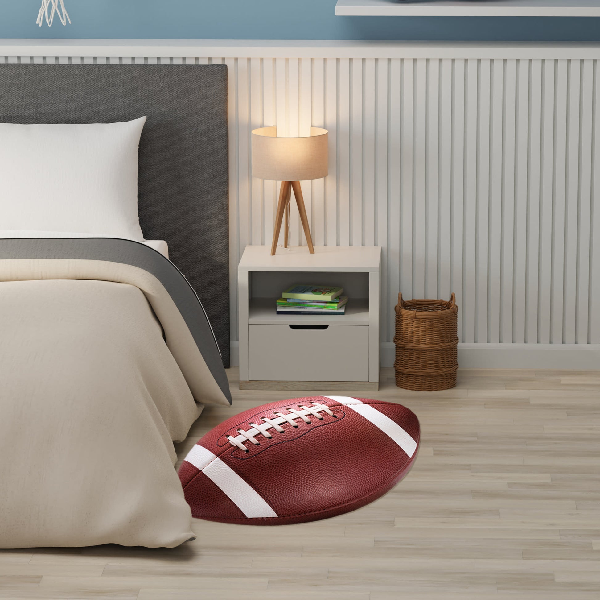 Red football-shaped rug with white laces beside beige bed, gray headboard, white nightstand with lamp, wicker basket.
