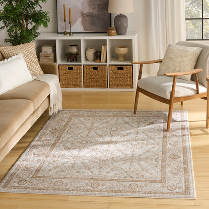 Beige and ivory patterned area rug in a light wood living room with a mid-century chair, beige sofa and wicker baskets.